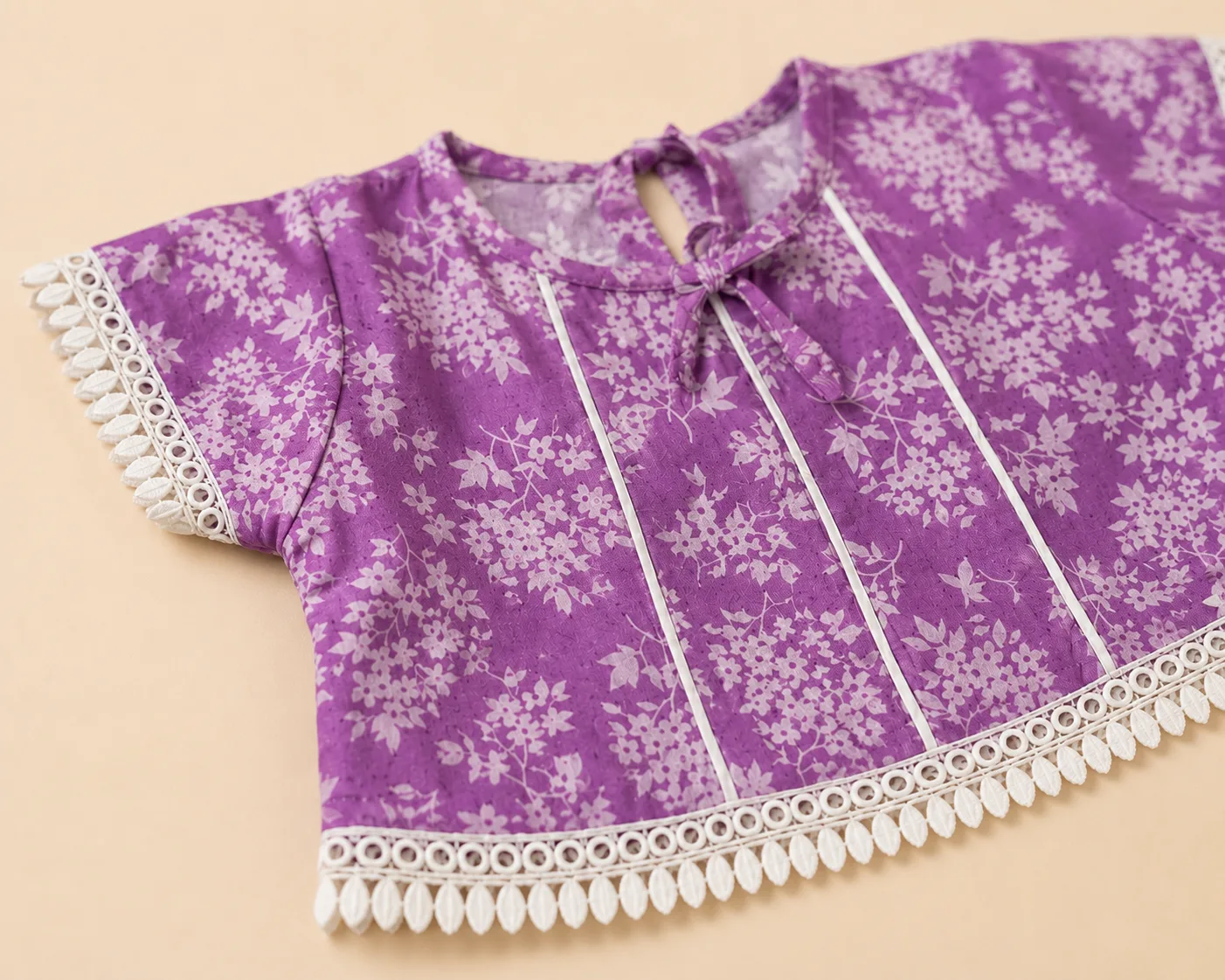 Close-up of pin-tucks and white scalloped lace