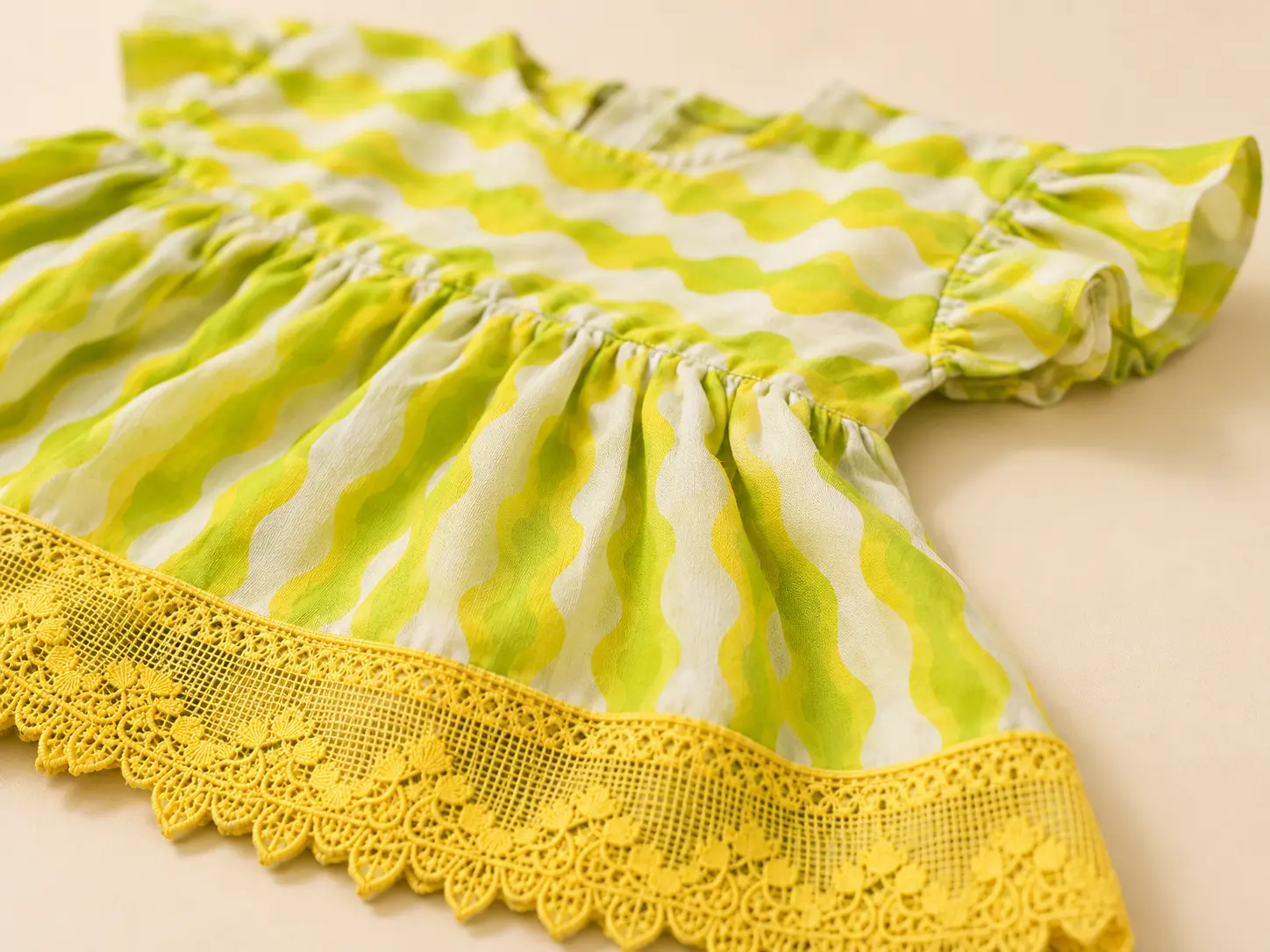 Close-up of yellow crochet lace and lime wave print